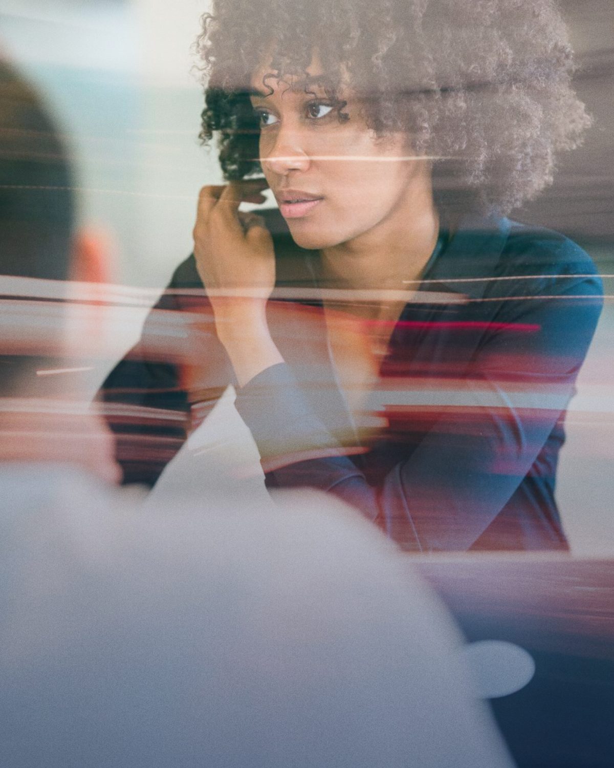 A woman listening closely in a meeting, with streaks of light passing in front